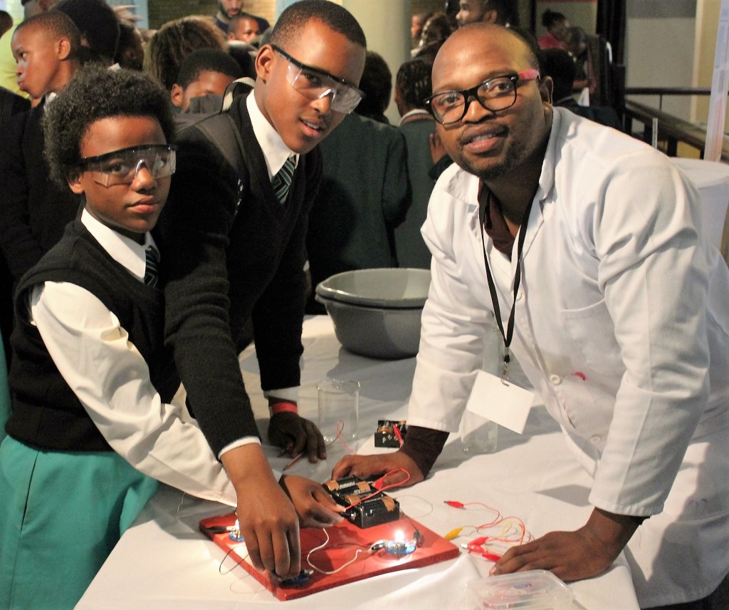 ELECTRICAL CONNECTION: SANRAL Centre of Excellence candidate Sonwabile Dlanjwa (right) explains how the electric circuit board works to Nathina Tanda (left) and Siseko Tenge, both in Grade 7 at Grahamstown SDA  Primary School. SANRAL displayed various science experiments at the Scifest Africa in Grahamstown.